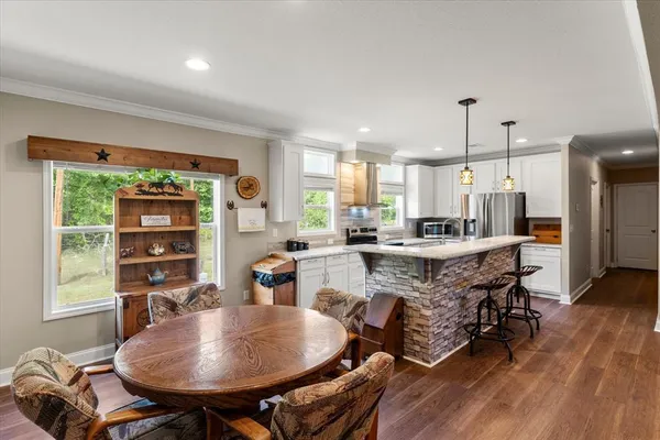 a kitchen with a table chairs stove and kitchen view