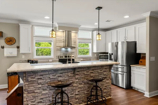a kitchen with kitchen island granite countertop a stove a sink and a refrigerator