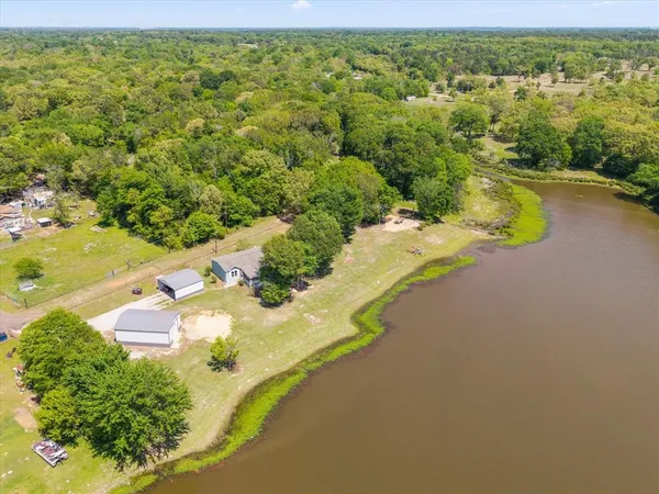 an aerial view of a house with a yard and lake view