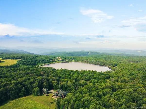 a view of a lake in front of house with outdoor seating