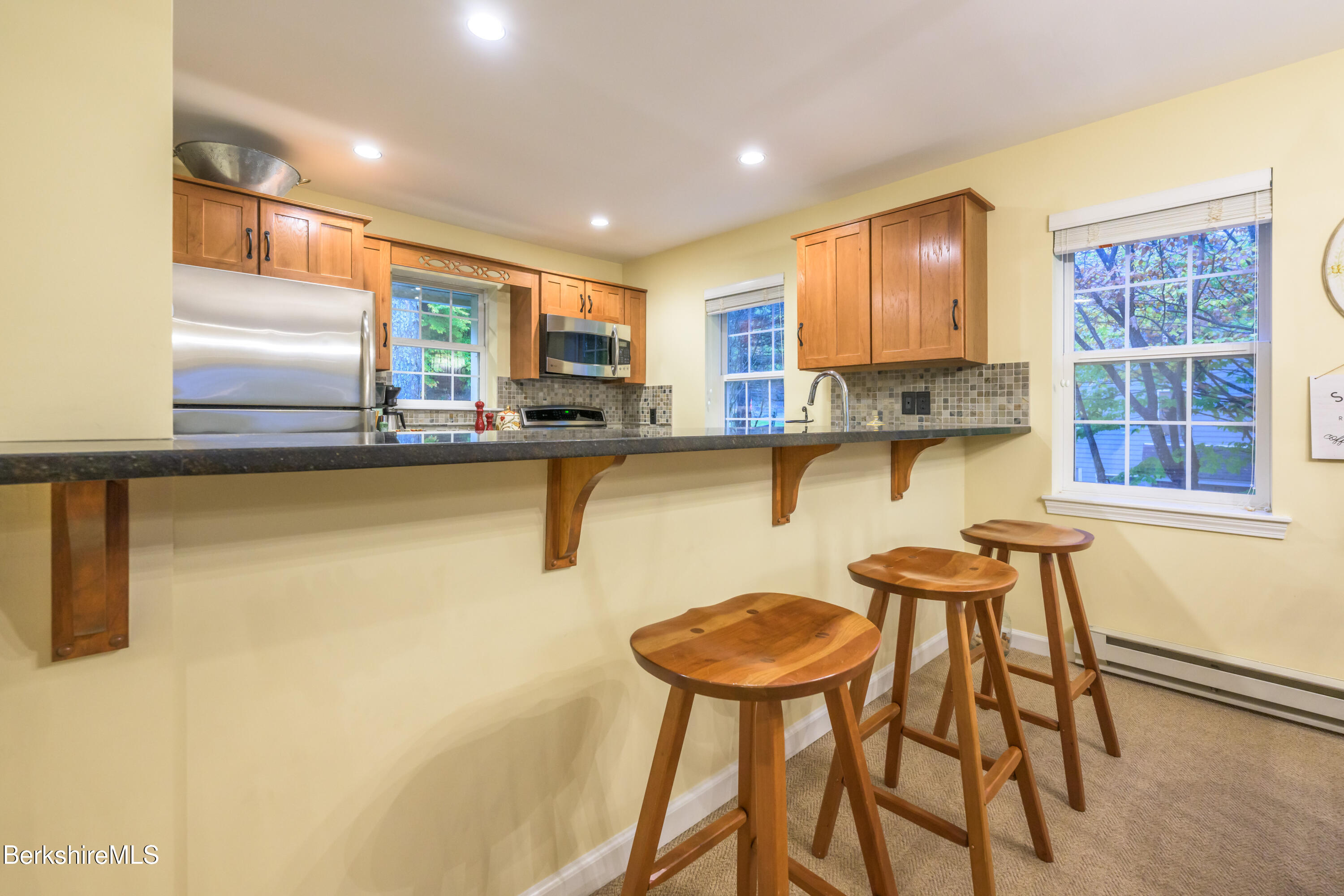 9341 Mountainside Drive Hancock, MA 01237 - Photo 15 of 43 a kitchen with stainless steel appliances a table and chairs in it