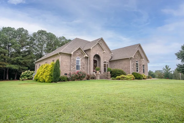 a front view of house with yard and green space