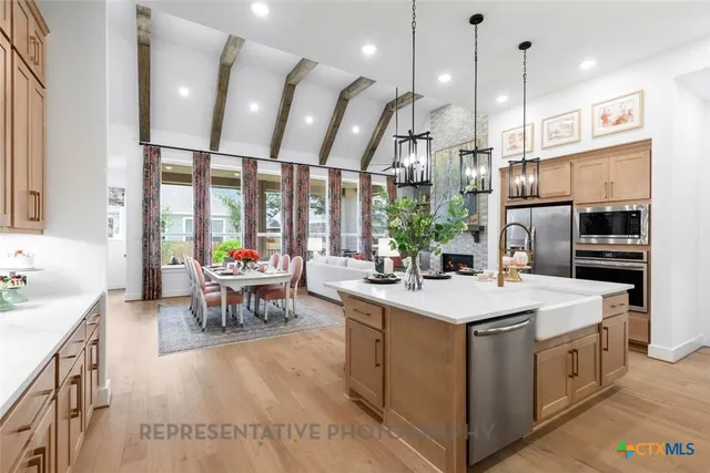a kitchen with kitchen island granite countertop a sink cabinets and stainless steel appliances