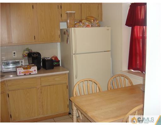 8607 Hana Road Edison, NJ 08817 - Photo 3 of 9 a kitchen with a refrigerator a sink and cabinets