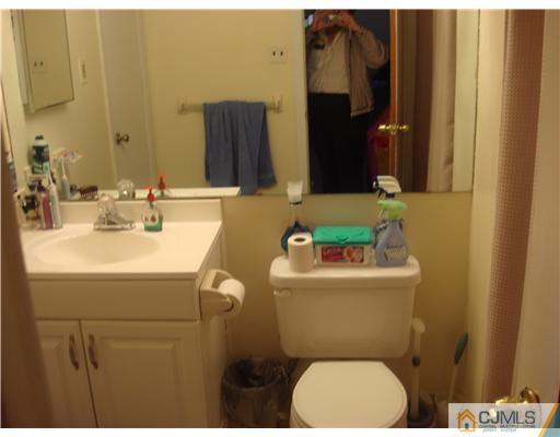8607 Hana Road Edison, NJ 08817 - Photo 5 of 9 a bathroom with a sink mirror vanity and toilet