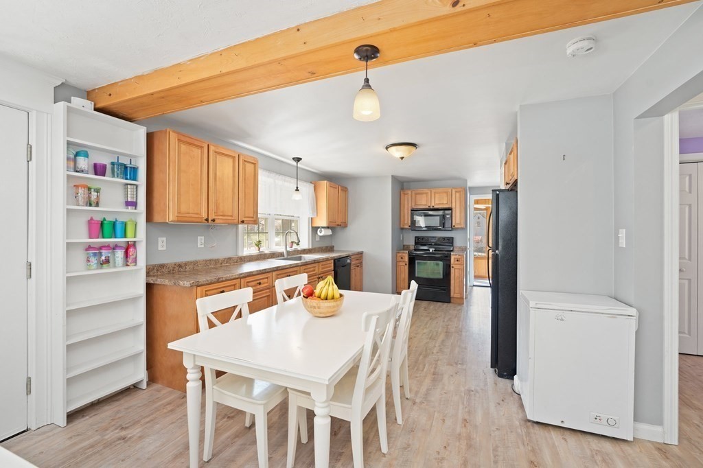 107 Brookfield Road Sturbridge, MA 01518 - Photo 3 of 36 a kitchen with stainless steel appliances granite countertop a refrigerator a sink dishwasher and white cabinets with wooden floor