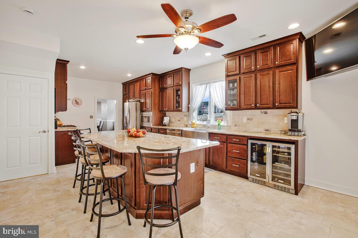 201 Charles Road Linthicum Heights, MD 21090 - Photo 17 of 50 a kitchen with stainless steel appliances granite countertop a stove a sink dishwasher and a refrigerator with wooden cabinets