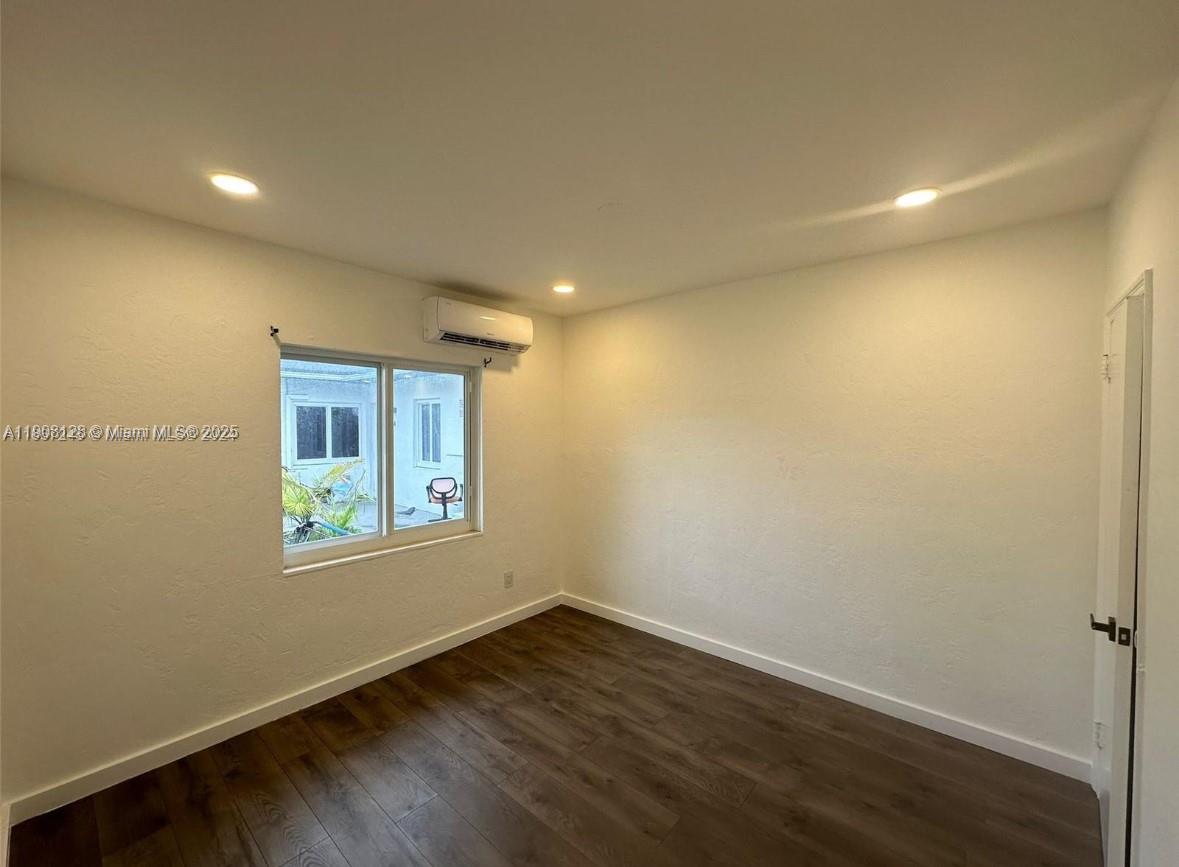 17175 Northeast 19th Avenue, Unit 6 North Miami Beach, FL 33162 - Photo 11 of 12 a view of an empty room with wooden floor and a window