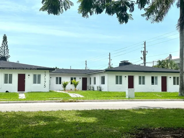 a front view of a house with a garden and yard