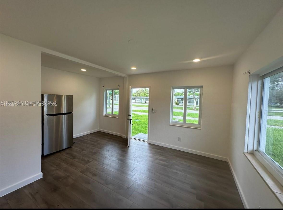 17175 Northeast 19th Avenue, Unit 6 North Miami Beach, FL 33162 - Photo 2 of 12 an empty room with wooden floor and windows