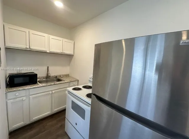a kitchen with stainless steel appliances a refrigerator sink and cabinets