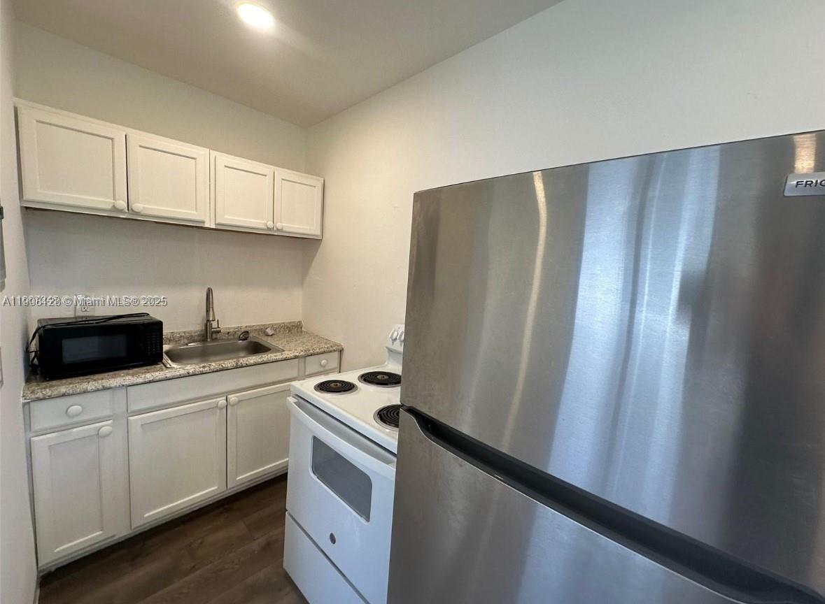 17175 Northeast 19th Avenue, Unit 6 North Miami Beach, FL 33162 - Photo 5 of 12 a kitchen with stainless steel appliances a refrigerator sink and cabinets