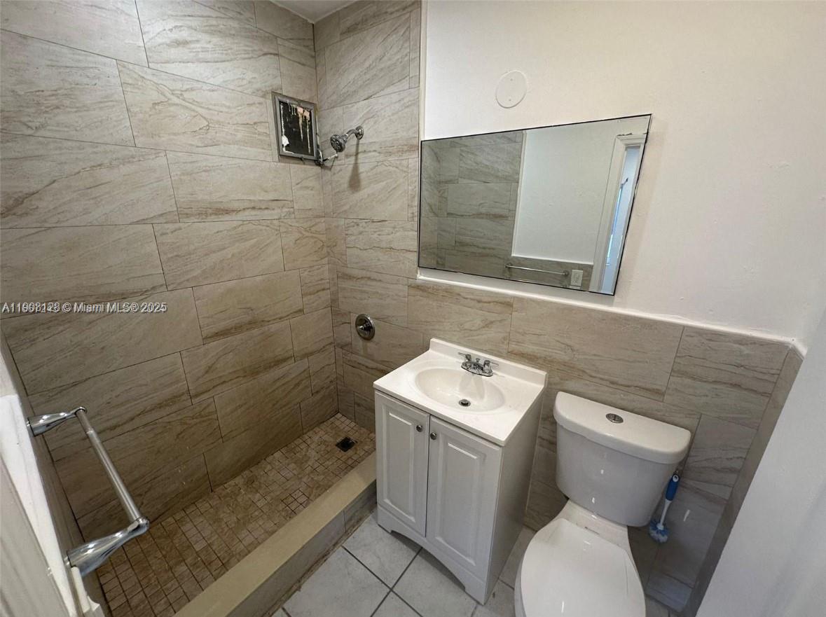 17175 Northeast 19th Avenue, Unit 6 North Miami Beach, FL 33162 - Photo 8 of 12 a bathroom with a toilet sink and mirror