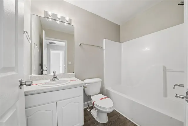 a bathroom with a sink a toilet a mirror and shower