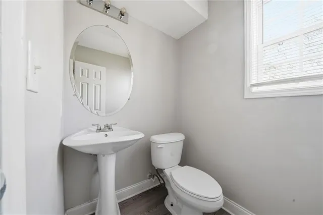 a bathroom with a toilet a sink and mirror