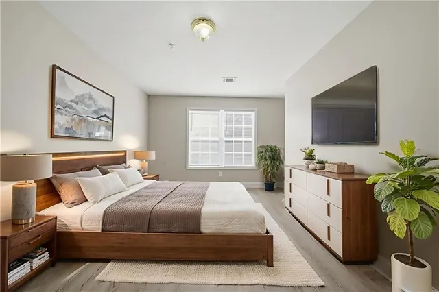 a bedroom with a large bed and a flat screen tv