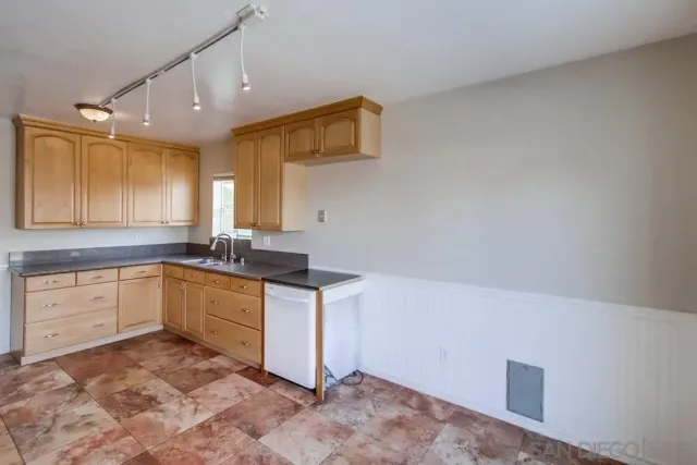 a kitchen with granite countertop a sink cabinets and window