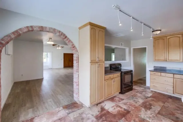 a kitchen with granite countertop a stove a sink and a refrigerator