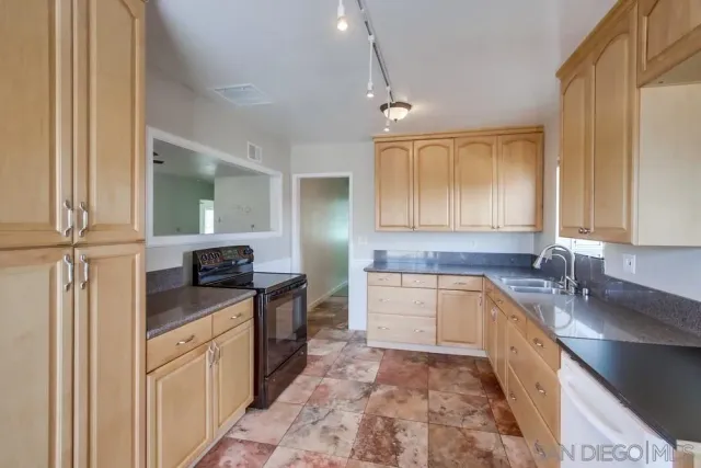 a kitchen with stainless steel appliances granite countertop a sink stove and cabinets