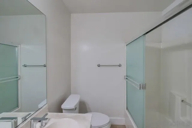 a white toilet sitting next to a bathroom sink