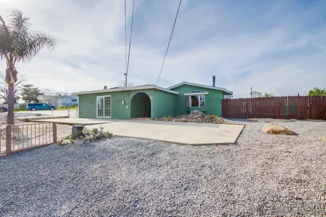 a view of a house with a yard and sitting area