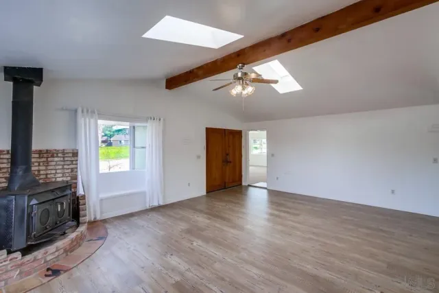 an empty room with windows and ceiling fan