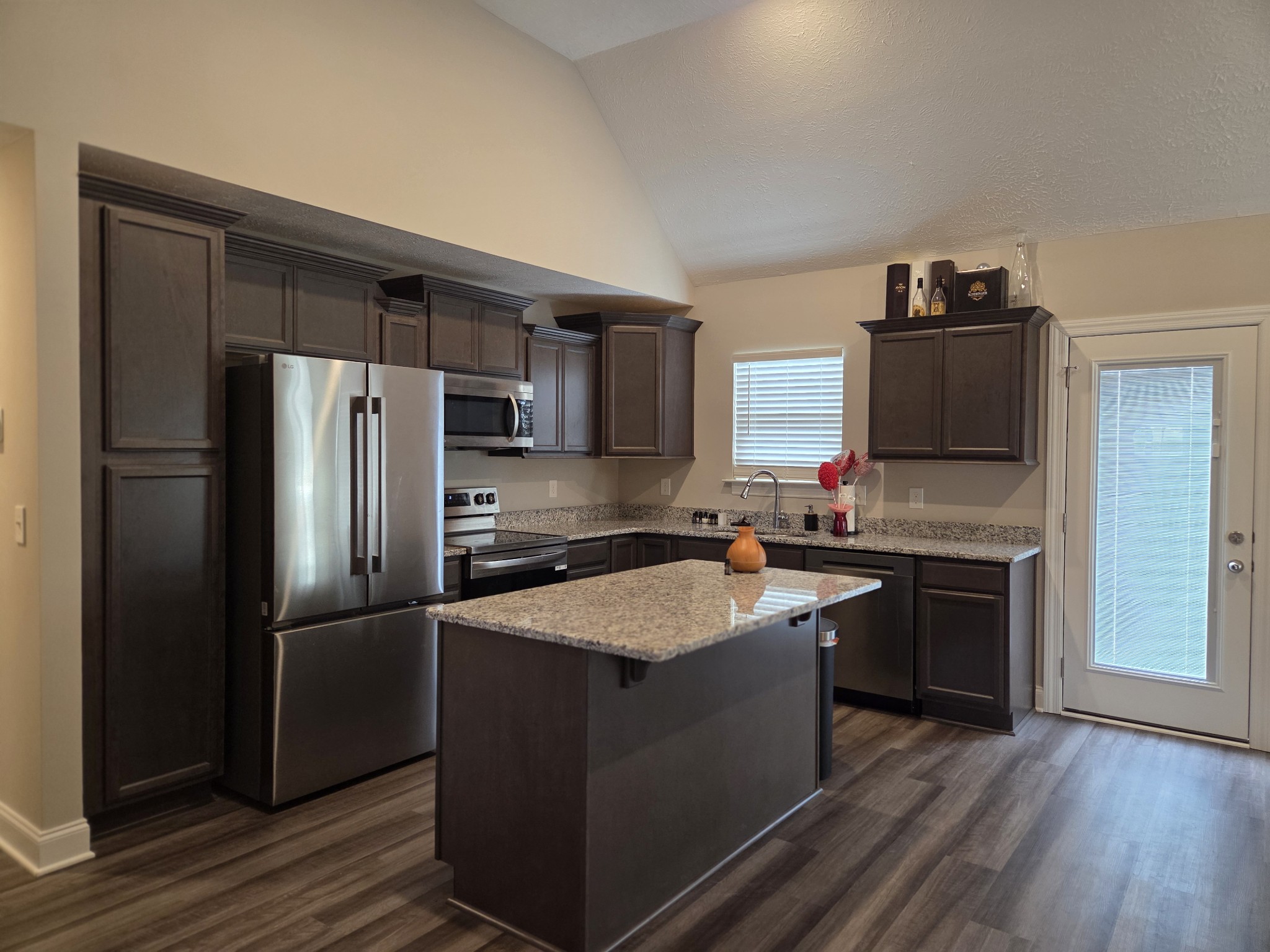2101 Red Barn Road Christiana, TN 37037 - Photo 64 of 76 a kitchen with granite countertop stainless steel appliances and wooden cabinets