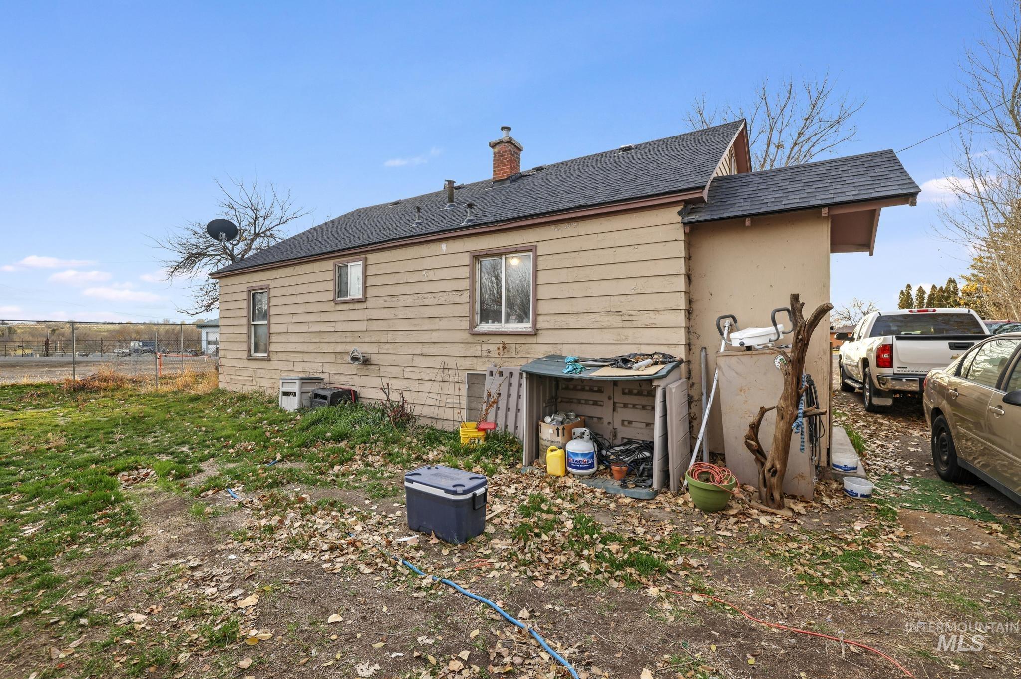 669 Locust Street South Twin Falls, ID 83301 - Photo 19 of 37 Back of property featuring a shingled roof and a chimney
