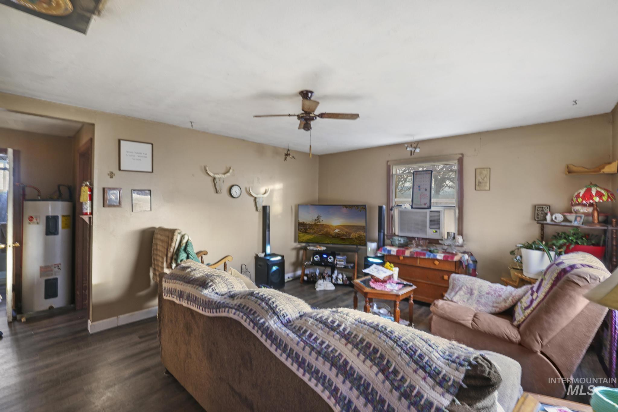 669 Locust Street South Twin Falls, ID 83301 - Photo 5 of 37 Living area with water heater, plenty of natural light, and dark wood-style flooring