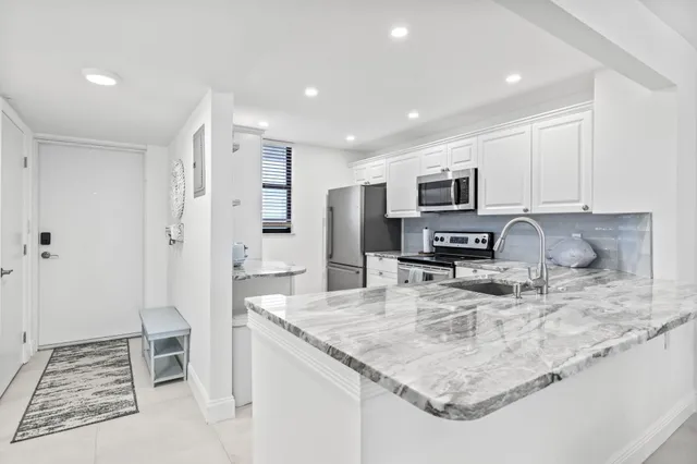 a kitchen with stainless steel appliances granite countertop a sink stove and refrigerator