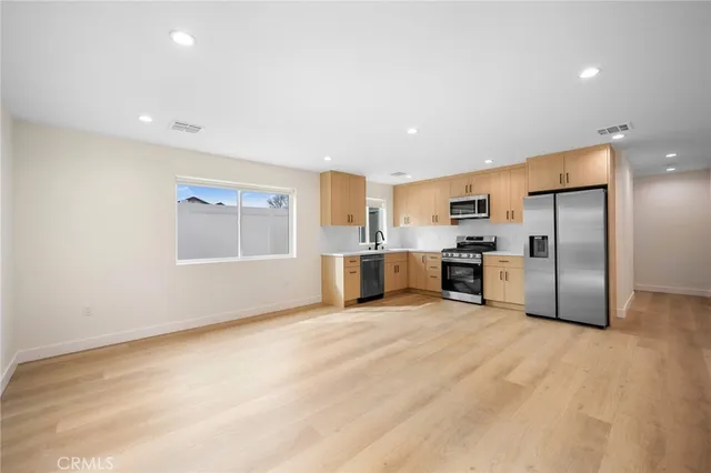 a kitchen with stainless steel appliances a refrigerator sink and stove