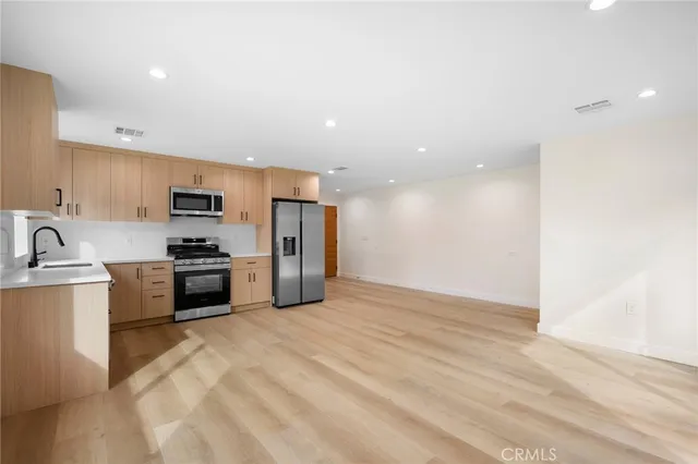 a kitchen with stainless steel appliances granite countertop a refrigerator sink and stove