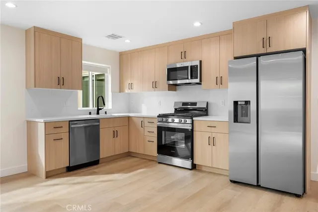 a kitchen with stainless steel appliances granite countertop a stove top oven microwave and sink