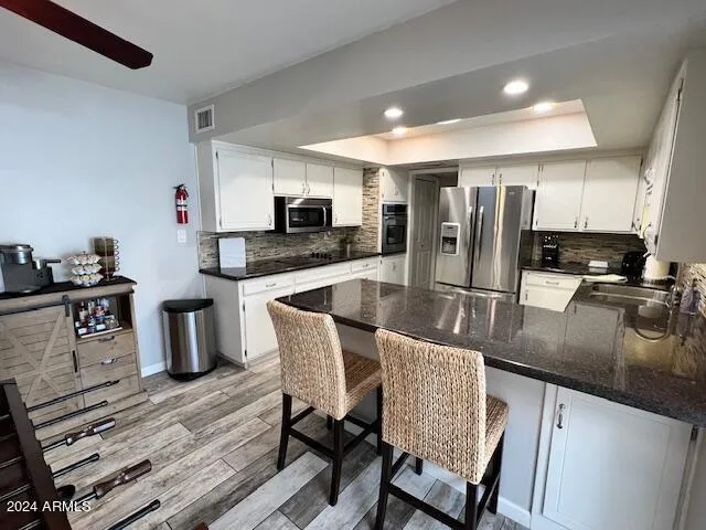 a kitchen with stainless steel appliances granite countertop a stove refrigerator and microwave