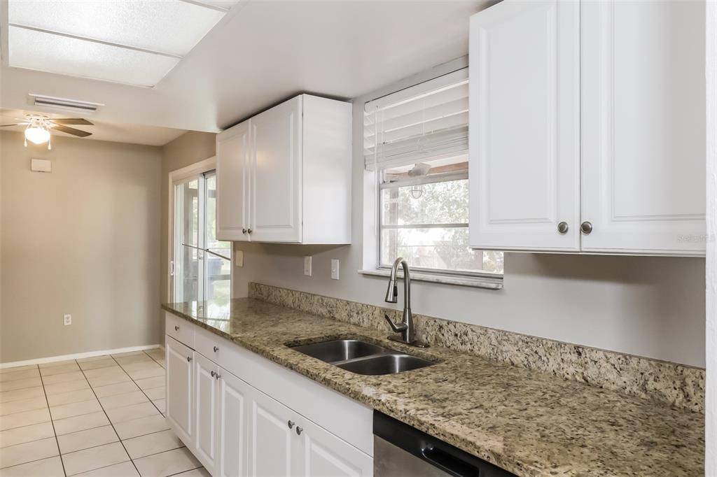 12125 Shadow Ridge Boulevard Hudson, FL 34669 - Photo 8 of 21 a kitchen with granite countertop a sink a stove and cabinets