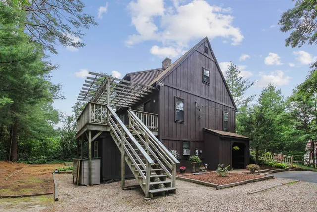 a view of backyard with wooden deck and a garden