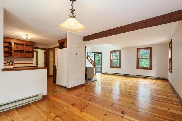 a view of a kitchen with furniture and wooden floor
