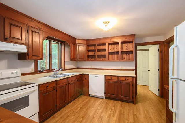 a kitchen with stainless steel appliances granite countertop cabinets wooden floors and a sink