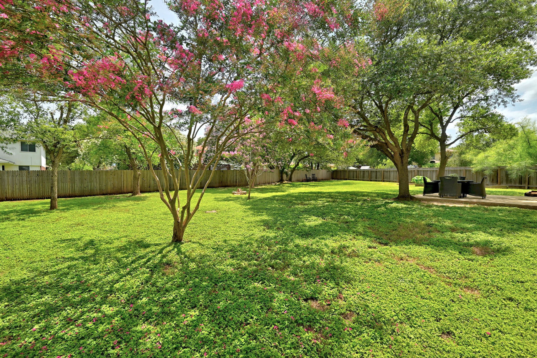 1801 Monks Tale Court Austin, TX 78748 - Photo 29 of 36 A spacious yard with mature trees and a wooden privacy fence, perfect for outdoor enjoyment.