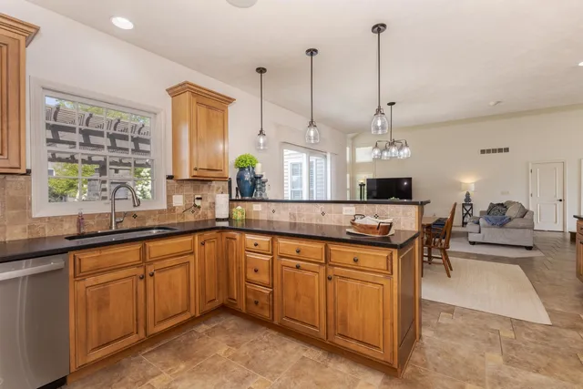 a open kitchen with stainless steel appliances granite countertop a sink a stove and a wooden floors
