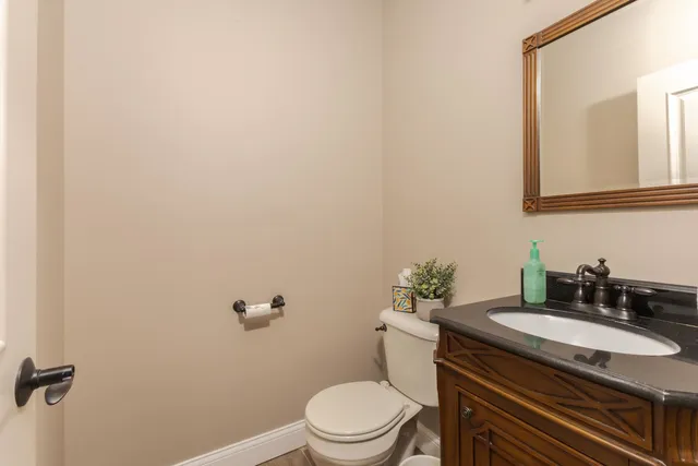 a bathroom with a granite countertop toilet sink and mirror