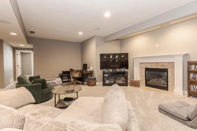 a living room with furniture a fireplace and a flat screen tv