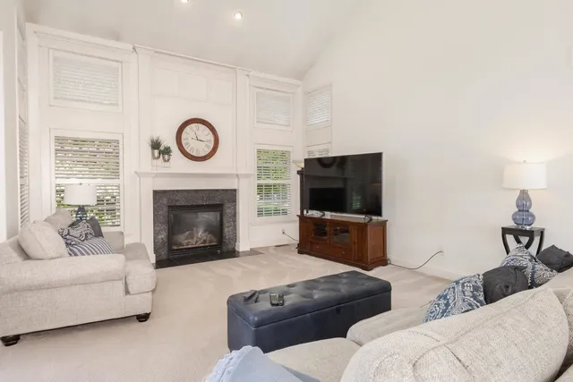 a living room with couches a fireplace and a flat screen tv