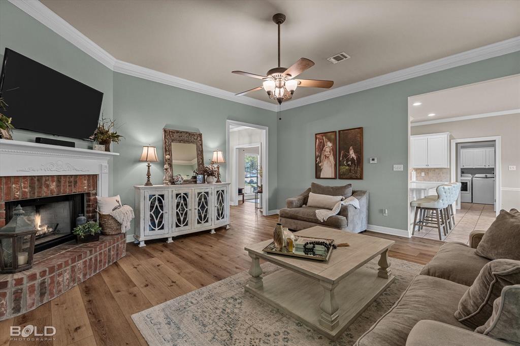 116 Augusta Avenue Benton, LA 71006 - Photo 9 of 38 a living room with furniture a flat screen tv and a fireplace