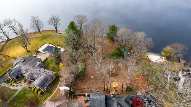 a view of a yard with plants and wooden fence