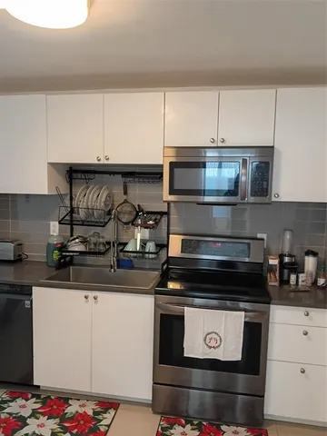 a kitchen with stainless steel appliances granite countertop a stove and a microwave