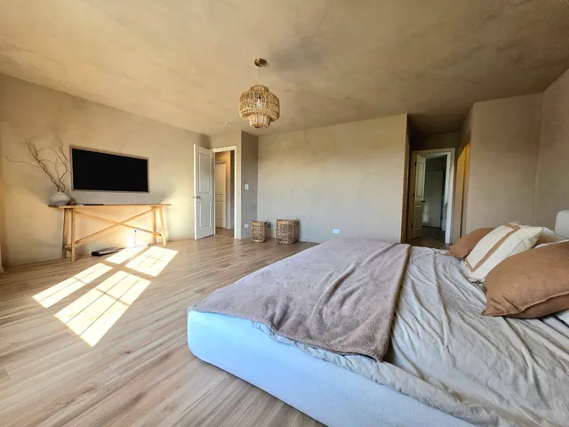 a spacious bedroom with two beds and a chair