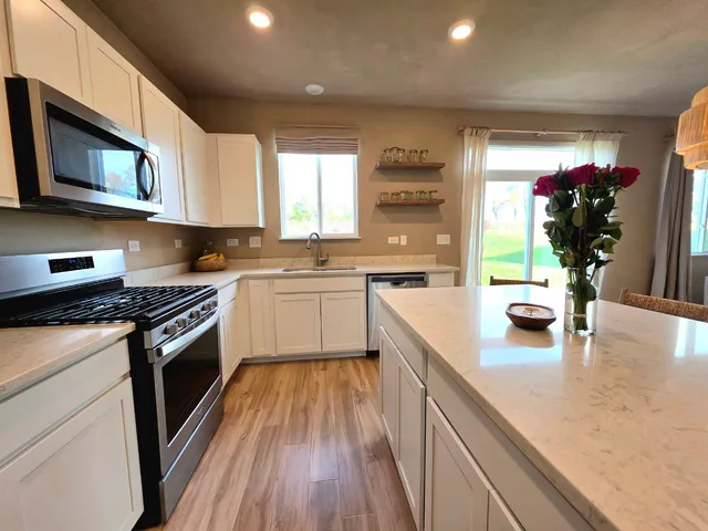 a kitchen with a sink a stove and cabinets