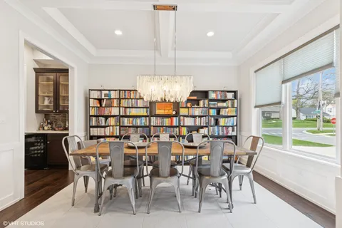 a dining room with furniture and a floor to ceiling window