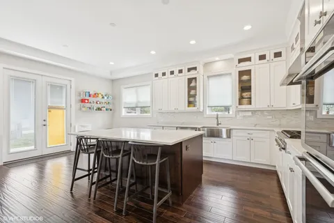 a kitchen with stainless steel appliances granite countertop a kitchen island a stove a table and chairs in it